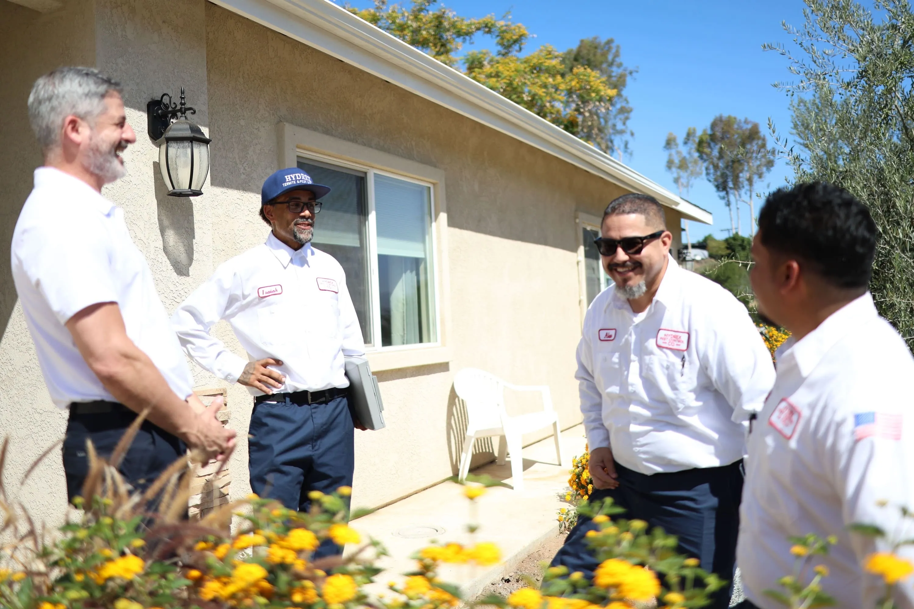 Hydrex Pest Control San Diego team meeting with a homeowner outside their house
